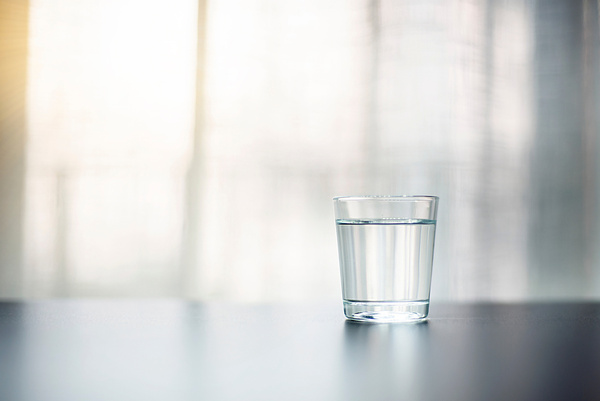 A clear glass of water on a table with soft daylight